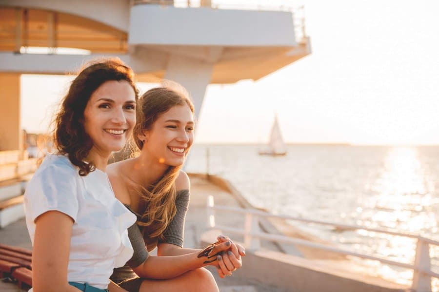 Close-up portrait of happy mother with teenage daughter. Sunset light.